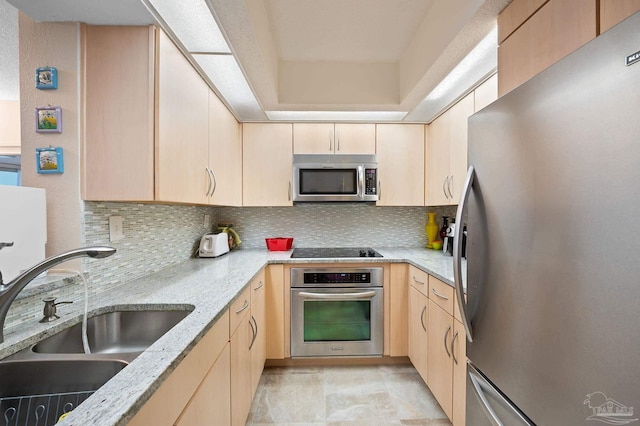 13753 Perdido Key Dr Unit 504, Perdido Key, FL 32507 - kitchen featuring stainless steel appliances, light brown cabinets, a sink, decorative backsplash, and light stone counters
