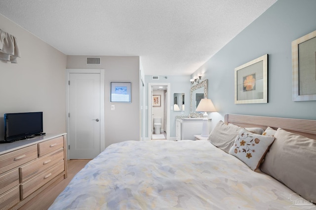 13753 Perdido Key Dr Unit 504, Perdido Key, FL 32507 - bedroom with light wood-type flooring, a textured ceiling, and connected bathroom