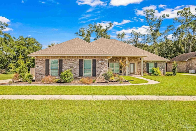 ranch-style house featuring brick siding, a shingled roof, and a front yard