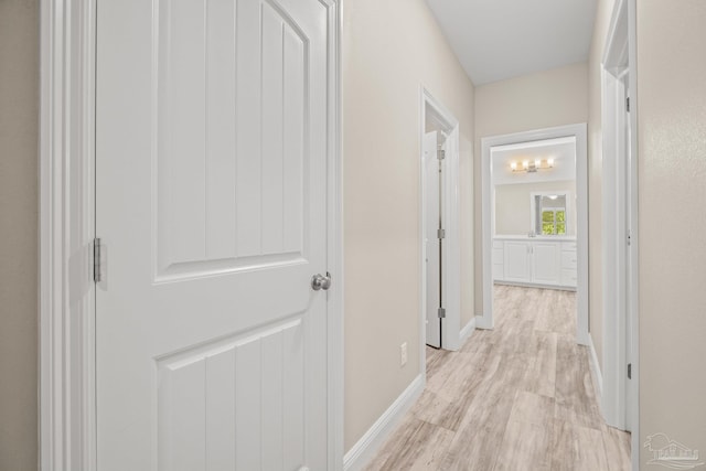 corridor with baseboards and light wood-style floors