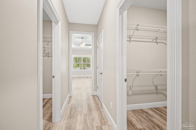 hall featuring baseboards and light wood-type flooring