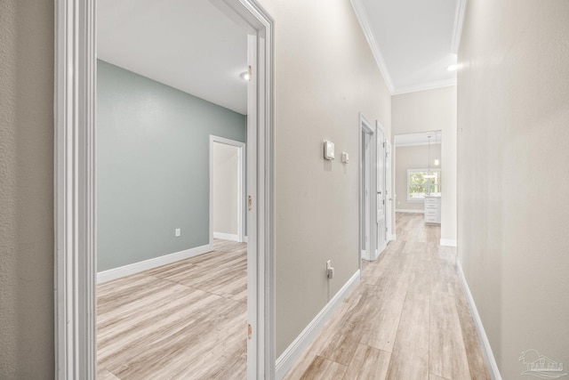 hallway featuring light wood-type flooring and ornamental molding