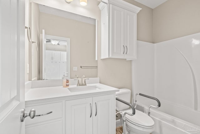 bathroom featuring vanity, bathtub / shower combination, and toilet