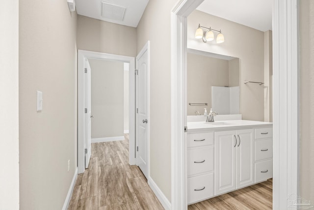 hallway with light hardwood / wood-style floors and sink