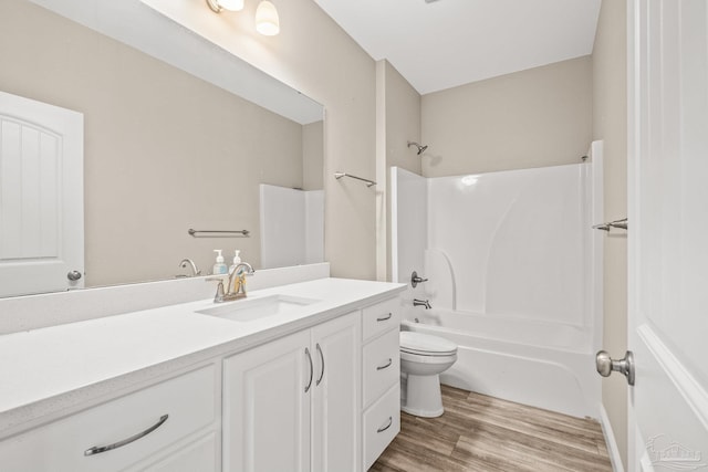 bathroom with vanity, shower / bathtub combination, wood finished floors, and toilet