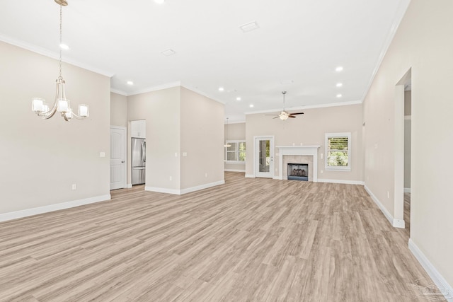 unfurnished living room with ceiling fan with notable chandelier, light hardwood / wood-style flooring, and ornamental molding