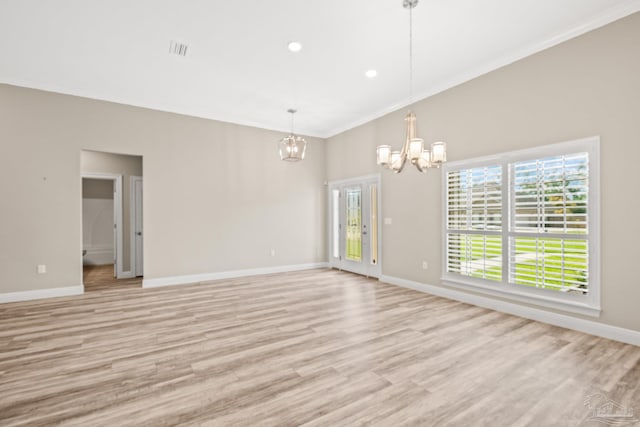 spare room with ornamental molding, visible vents, an inviting chandelier, baseboards, and light wood-type flooring