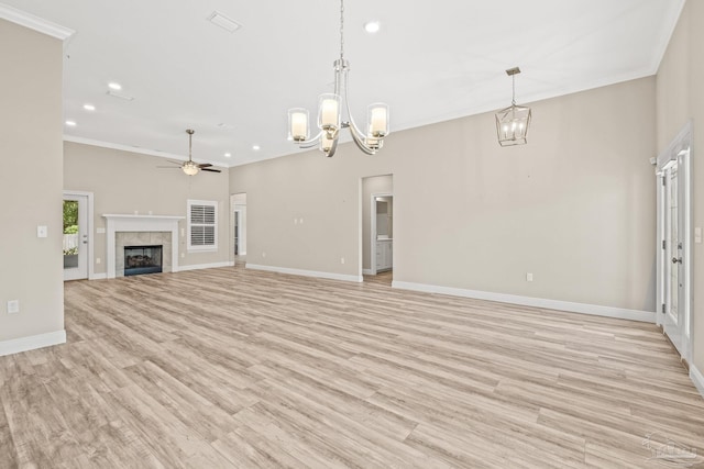 unfurnished living room with baseboards, a tile fireplace, crown molding, and light wood-type flooring