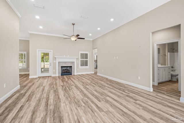 unfurnished living room with baseboards, light wood-style floors, crown molding, and a fireplace