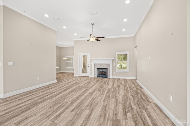 unfurnished living room with ceiling fan, light hardwood / wood-style flooring, crown molding, and a fireplace