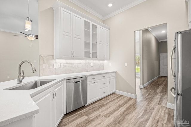 kitchen with appliances with stainless steel finishes, white cabinets, light countertops, and glass insert cabinets