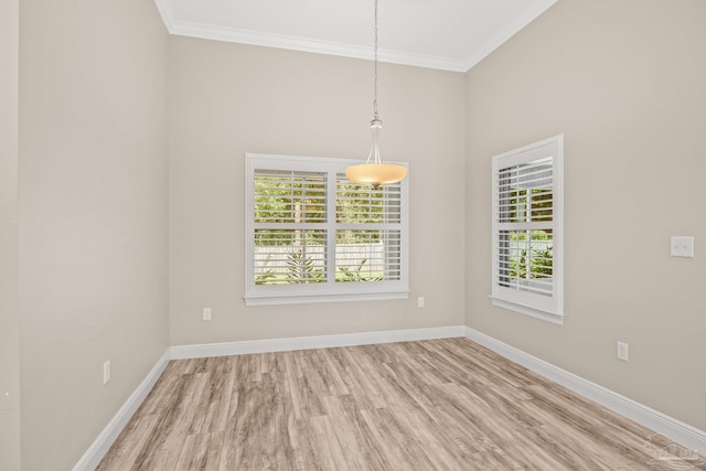 empty room with light hardwood / wood-style flooring and crown molding