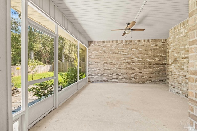 unfurnished sunroom with ceiling fan