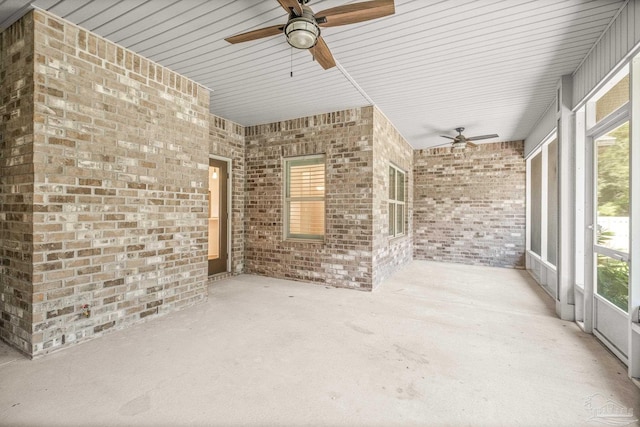 unfurnished sunroom featuring a ceiling fan