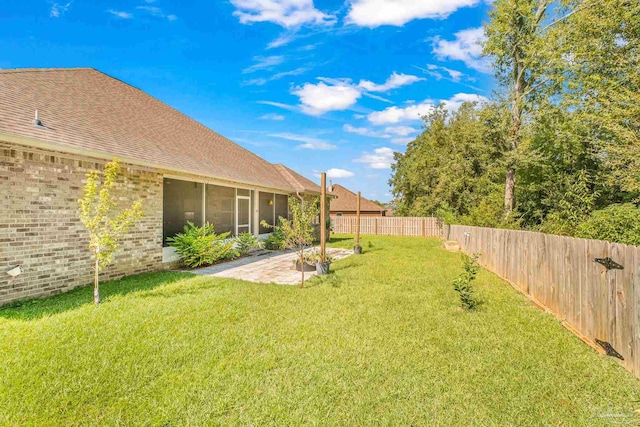 view of yard featuring a sunroom and a patio area