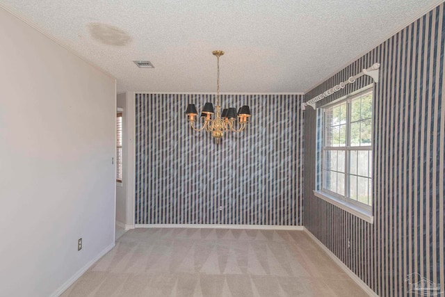 unfurnished dining area featuring a notable chandelier, a textured ceiling, and carpet flooring