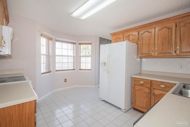 kitchen featuring white appliances, backsplash, a textured ceiling, and light tile patterned floors