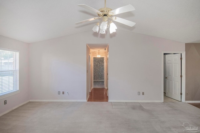 carpeted spare room featuring lofted ceiling, a textured ceiling, and ceiling fan