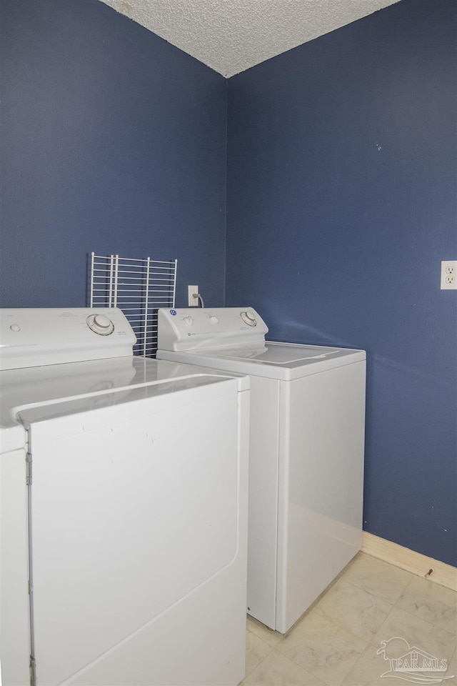 4416 Bellwood Cir, Pace, FL 32571 - washroom featuring a textured ceiling, separate washer and dryer, marble finish floor, baseboards, and laundry area