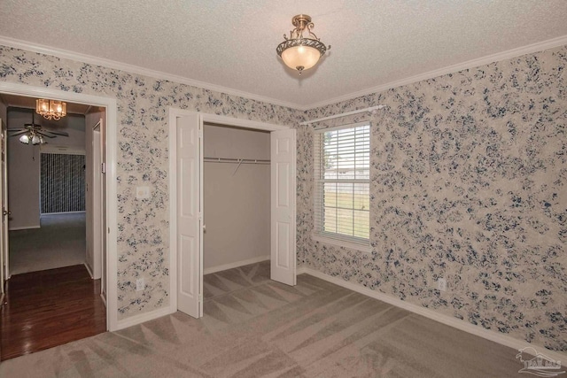 unfurnished bedroom with ornamental molding, a textured ceiling, and carpet flooring