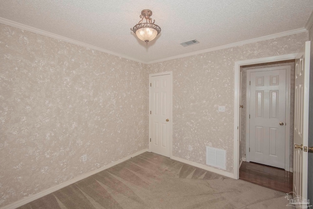 carpeted empty room with a textured ceiling and ornamental molding