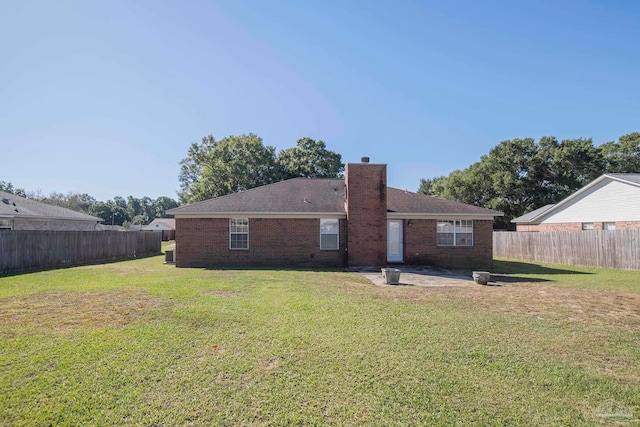 rear view of property with a patio and a lawn