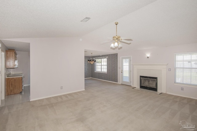 4416 Bellwood Cir, Pace, FL 32571 - unfurnished living room featuring a fireplace, vaulted ceiling, light colored carpet, and ceiling fan with notable chandelier
