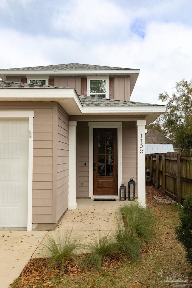 property entrance featuring board and batten siding and fence