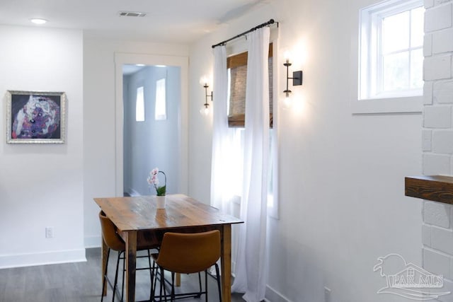 dining space featuring dark wood-type flooring, baseboards, and visible vents