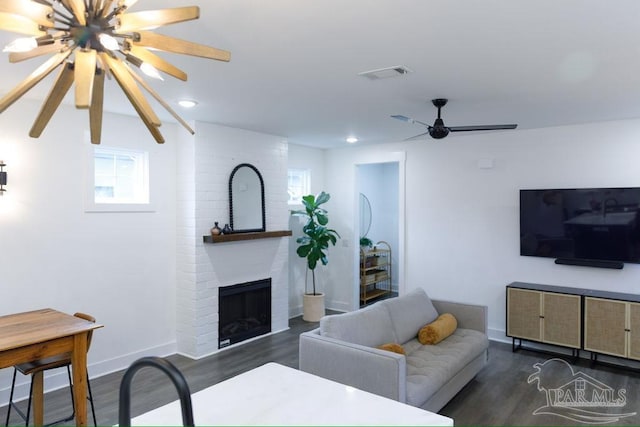 living area featuring visible vents, baseboards, dark wood-style floors, and a ceiling fan