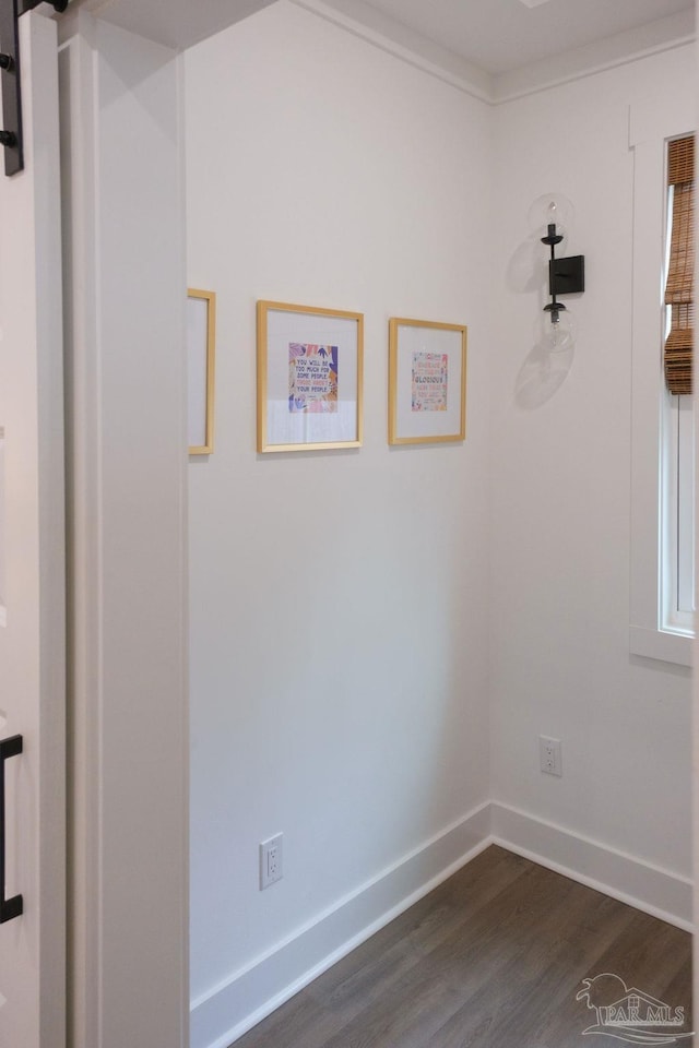 spare room featuring dark wood-style floors, baseboards, and ornamental molding