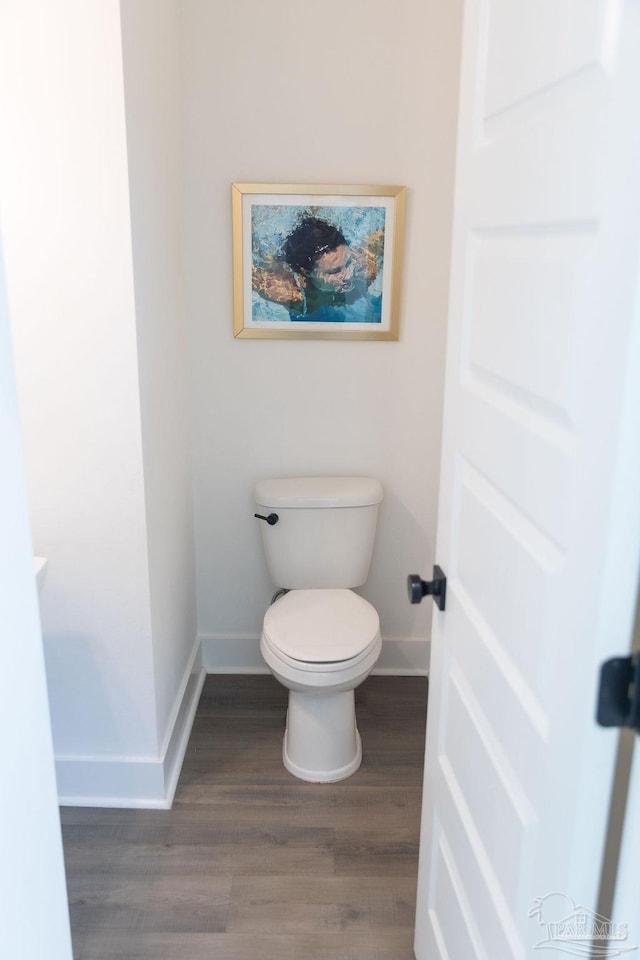 bathroom featuring toilet, baseboards, and wood finished floors