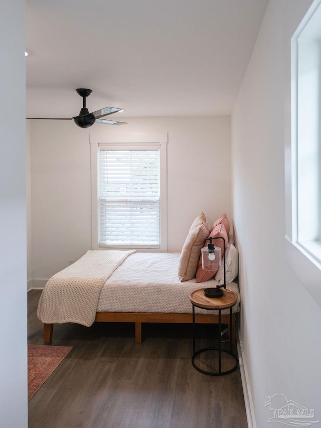 bedroom with ceiling fan, baseboards, and wood finished floors