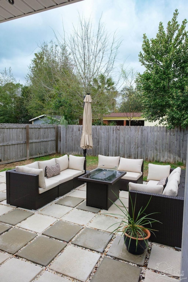 view of patio with an outdoor living space with a fire pit and a fenced backyard