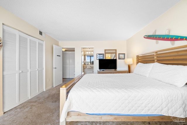 bedroom with connected bathroom, a closet, and carpet flooring