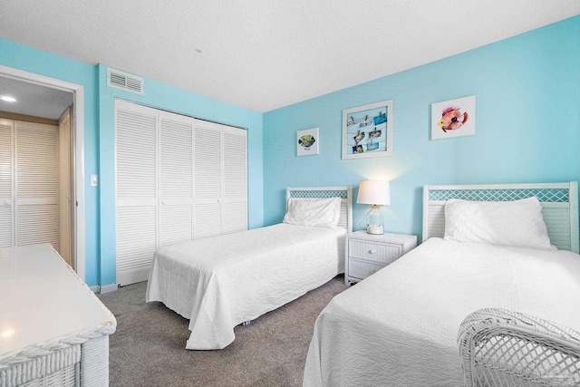 carpeted bedroom featuring a textured ceiling and a closet