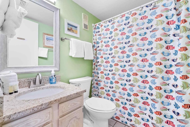 bathroom with tile patterned floors, vanity, toilet, and curtained shower