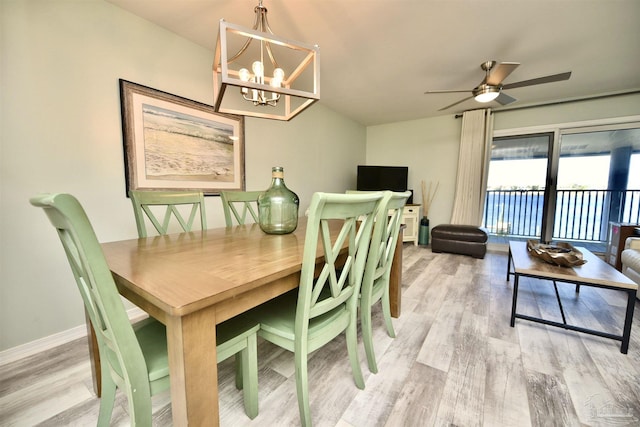 dining area with wood-type flooring and ceiling fan with notable chandelier