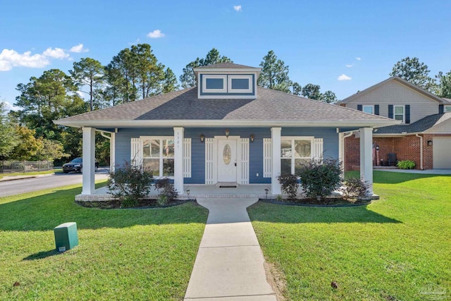 view of front of home with a front yard, covered porch, and a garage