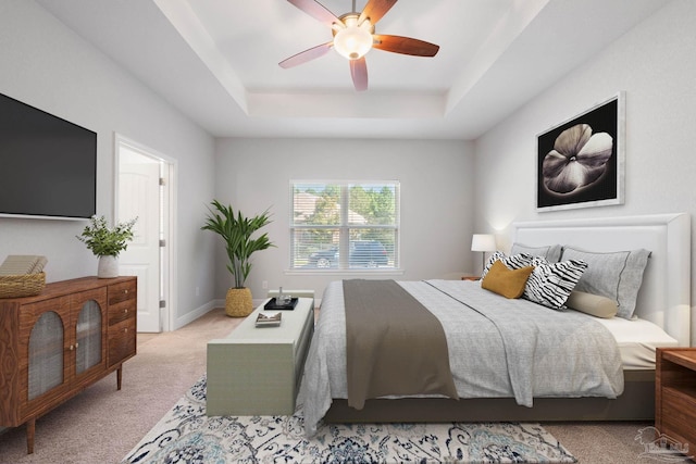 bedroom with ceiling fan, a raised ceiling, and light colored carpet