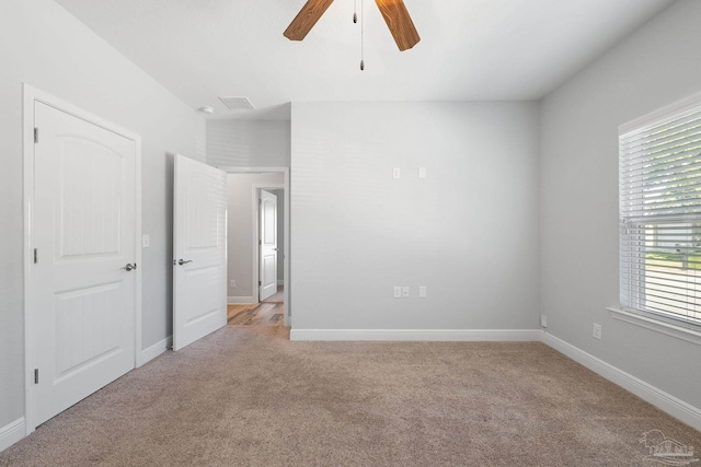 unfurnished room with light colored carpet and ceiling fan