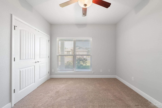 carpeted spare room with ceiling fan