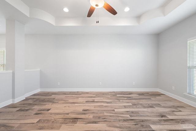 unfurnished room featuring ceiling fan, hardwood / wood-style flooring, and a wealth of natural light