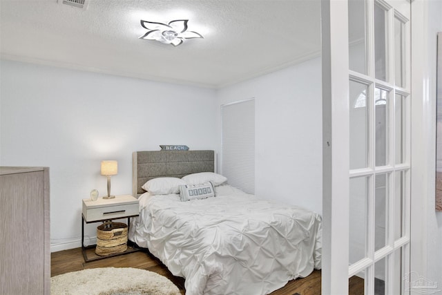 bedroom featuring dark hardwood / wood-style floors and a textured ceiling