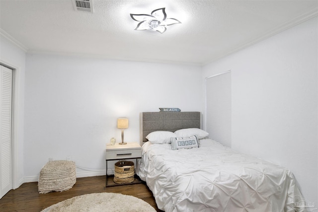 bedroom with dark hardwood / wood-style flooring, a textured ceiling, and ornamental molding