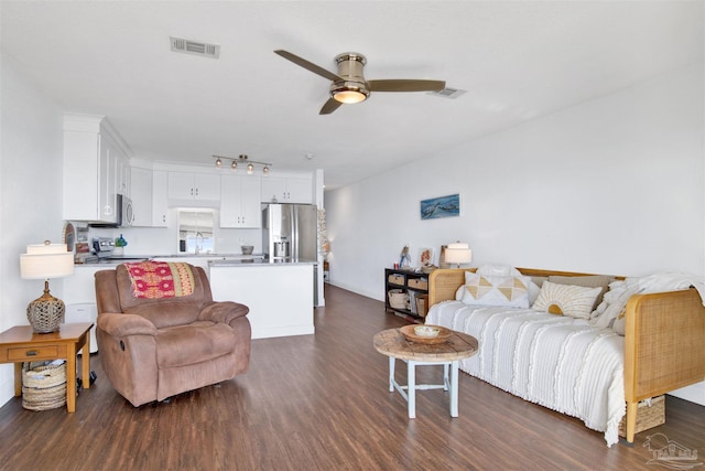 living room featuring dark hardwood / wood-style floors, ceiling fan, and sink