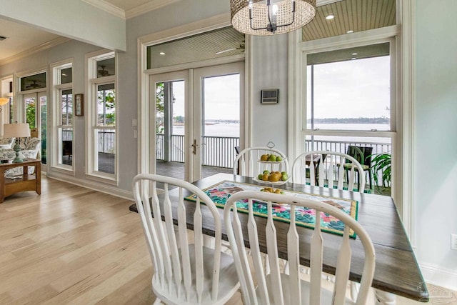 sunroom / solarium featuring a water view, visible vents, a chandelier, and french doors