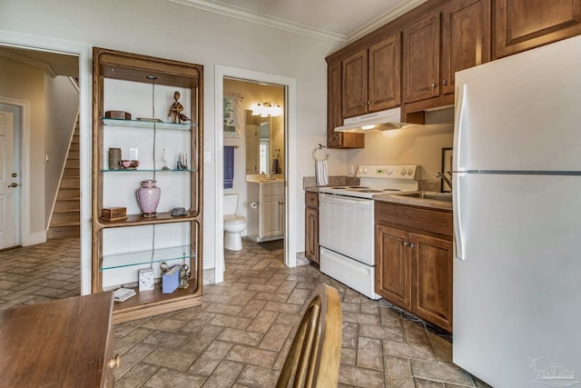 kitchen featuring white appliances, brown cabinets, crown molding, and under cabinet range hood