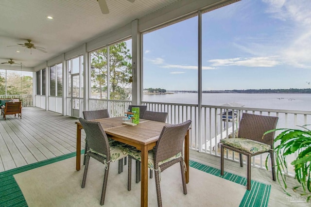 sunroom featuring a water view and ceiling fan