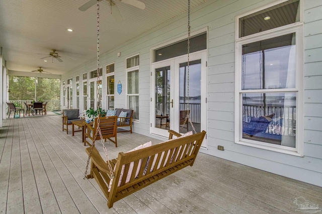 wooden terrace featuring outdoor dining space, ceiling fan, and an outdoor living space